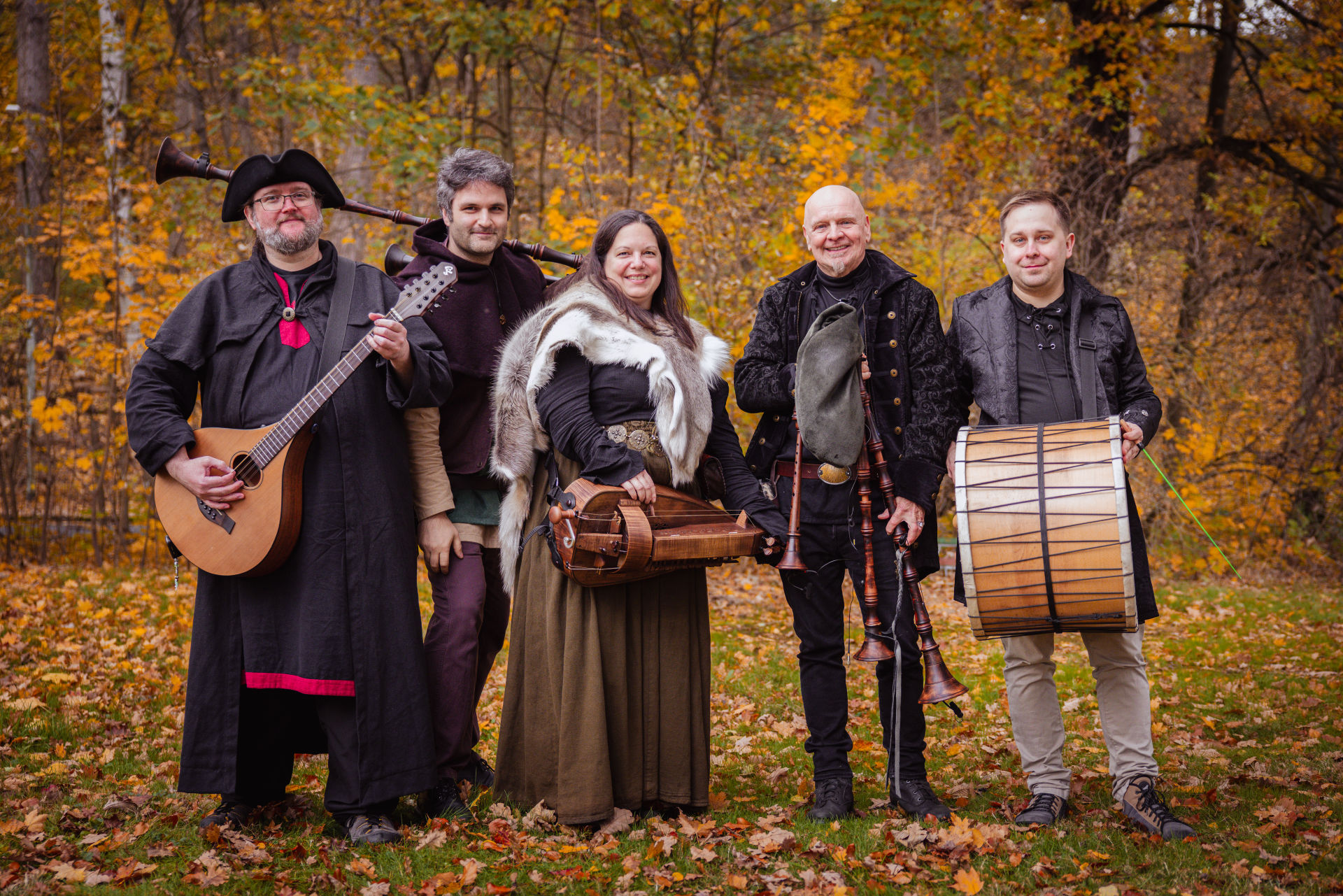 Die fünf Musiker von RabenAas in Gewandung mit Laute, Drehleier, Sackpfeife und Davul im herbstlichen Wald